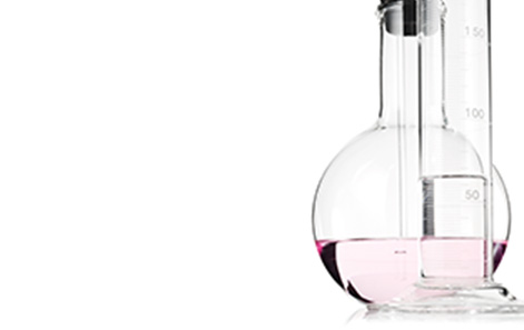 Scientific glassware holding light pink liquid against a white background. 