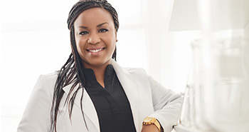 A picture of Dr. Shoná Burkes-Henderson, Senior Scientist, Clinical Research, a black female scientist, smiling in a scientific setting