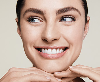 A picture of a smiling white brunette woman with clear skin