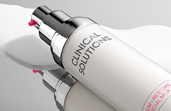 Clinical Solutions™ Calm+Restore Facial Milk on a mirror surrounded by fluid formula.