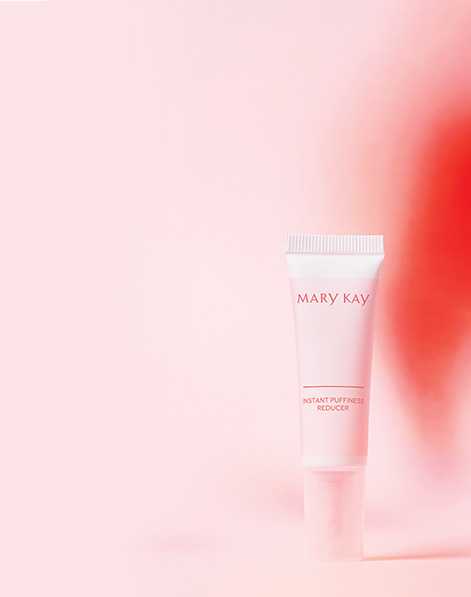 Picture of Instant Puffiness Reducer tube against a coral and pink background.