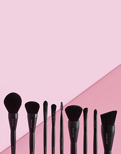 Mary Kay brushes standing against a pink background.