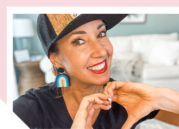 Image of woman smiling making a heart shape with her hands