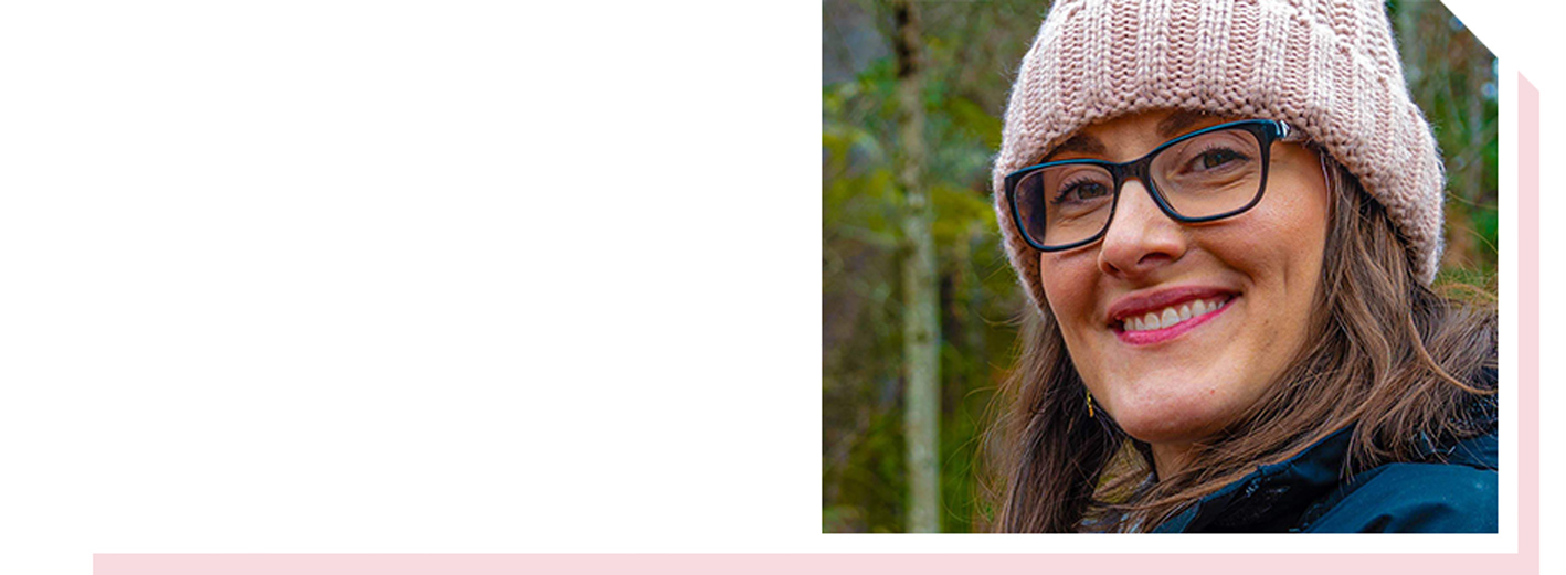Image of woman in glasses and beanie smiling