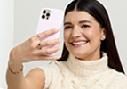 Medium-skinned woman holding up a phone with the screen facing towards her