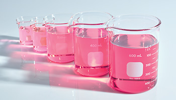 A picture of beakers filled with pink liquid