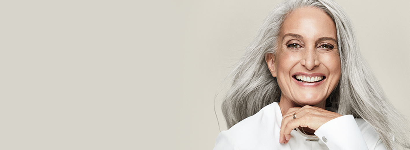 A smiling mature white woman with gray hair and beautiful skin