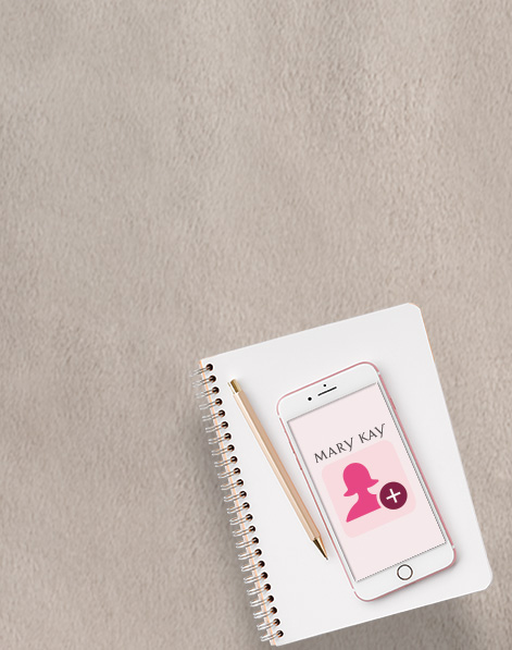 Phone showing Mary Kay screen resting on a notepad