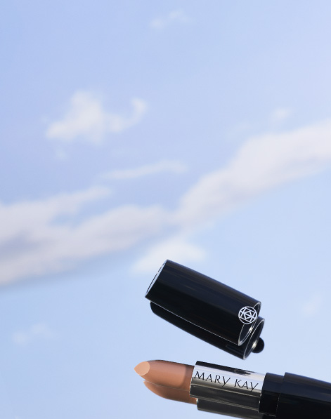 Open tube of Mary Kay Gel Semi-Matte Lipstick in shade Subdued Nude with sky-like background.