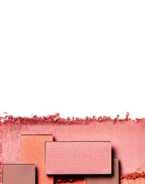 Assorted pans of new Mary Kay Chromafusion Blush sit atop swipes of vibrant colored powder. 