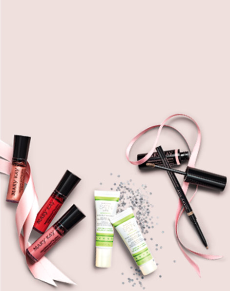 Nourishine Plus Lip Gloss, Mary Kay Satin Lips, Mary Kay Precision Brow Liner and Mary Kay Volumizing Brow Tint styled with ribbon and glitter on a light pink background.