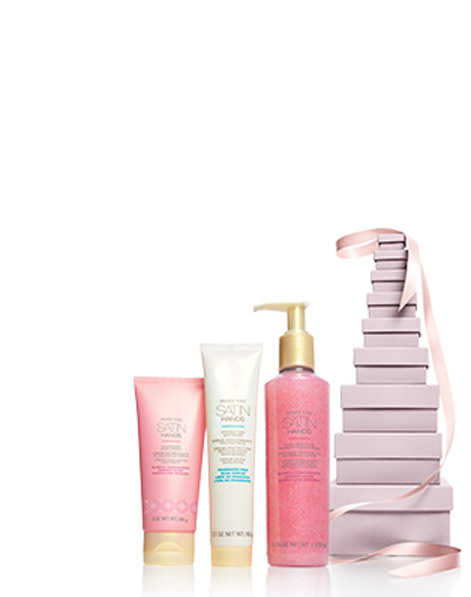 Limited Edition Satin Hands Blissful Pomegranate standing in front of a tall stack of pink gift boxes.