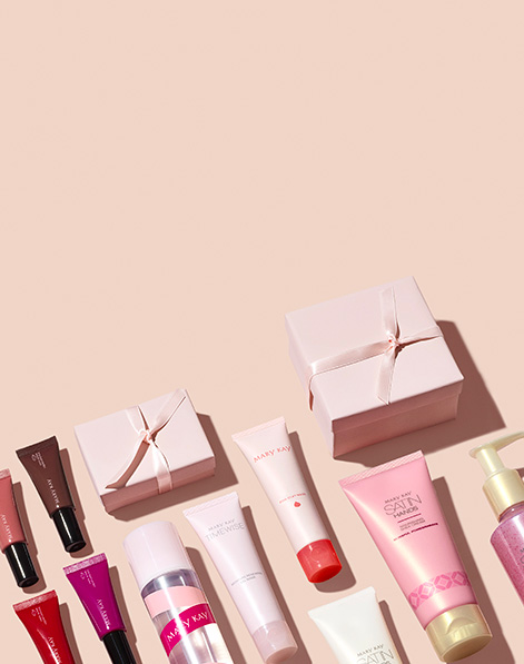 Women’s limited-edition gifting products with pink gift boxes artfully laid on a light pink background