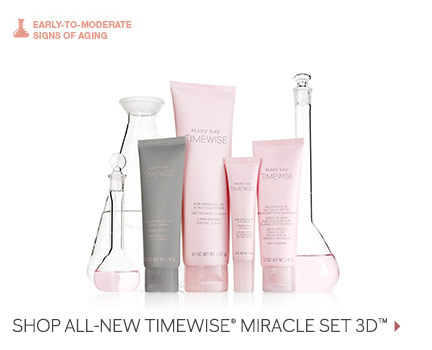 Four Mary Kay products from the new TimeWise Miracle Set 3D skin care regimen are shown in pink and grey packaging in front of glass beakers filled with pink liquid. The set includes the 4-in-1 Cleanser, the Day Cream SPF 30, the Night Cream and the Eye Cream.